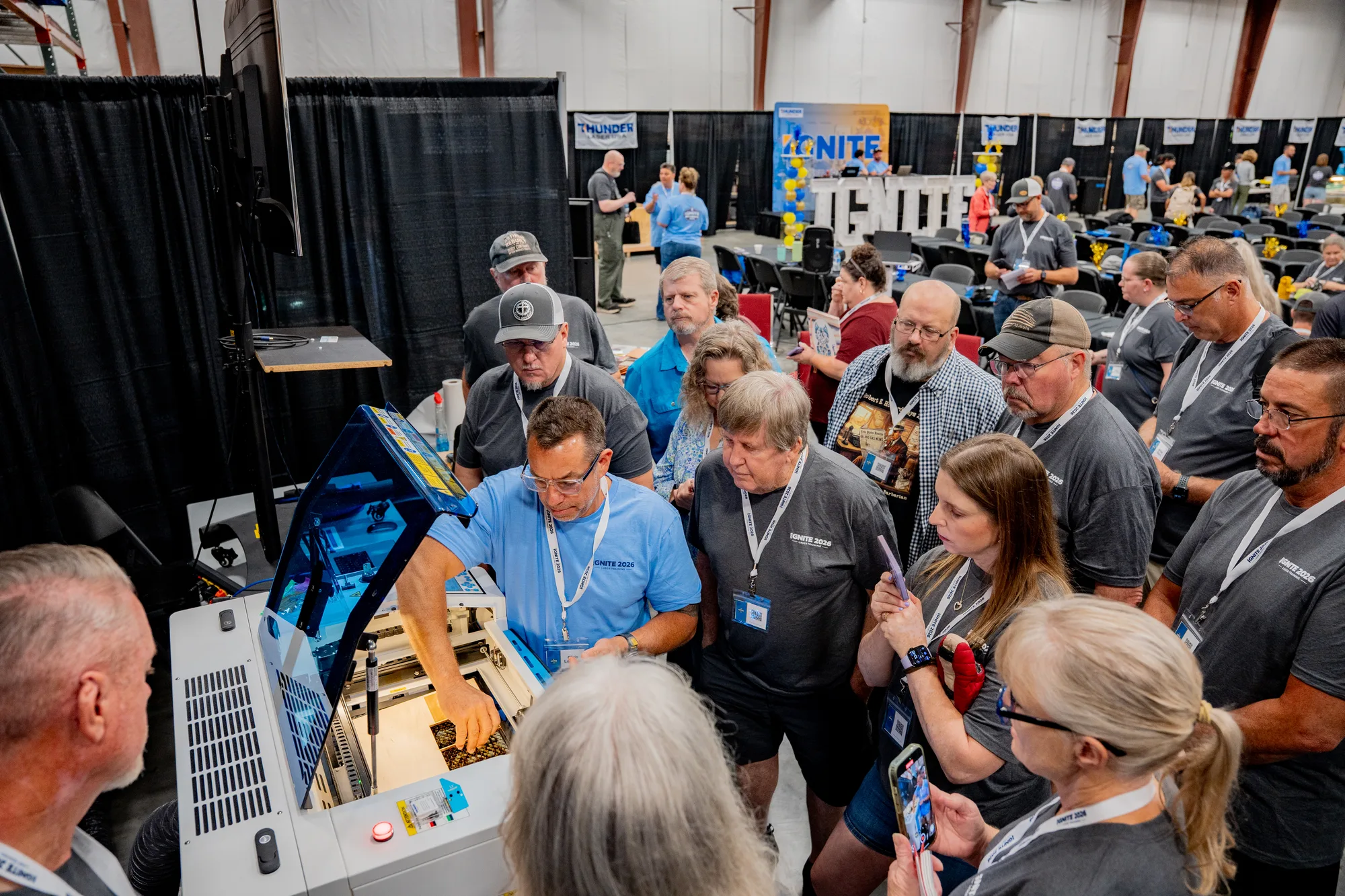 Owners gathered around a Thunder Laser at Ignite hands-on training